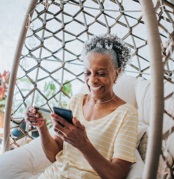 Woman holding phone and debit/credit card