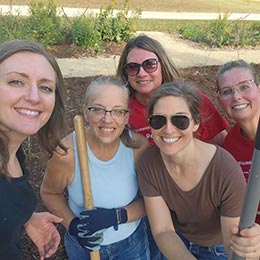 group of Shawano AbbyBank employees smiling while holding rakes and shovels during our annual volunteer day in October 2025