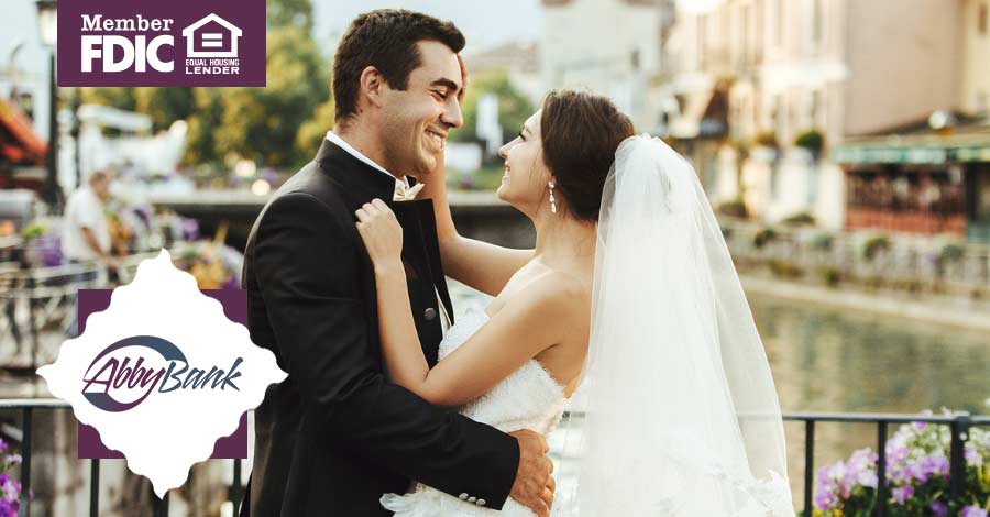 young man and woman smiling and embracing happily on their wedding day
