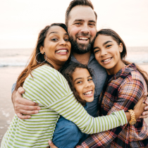 Family of four embracing on a beach