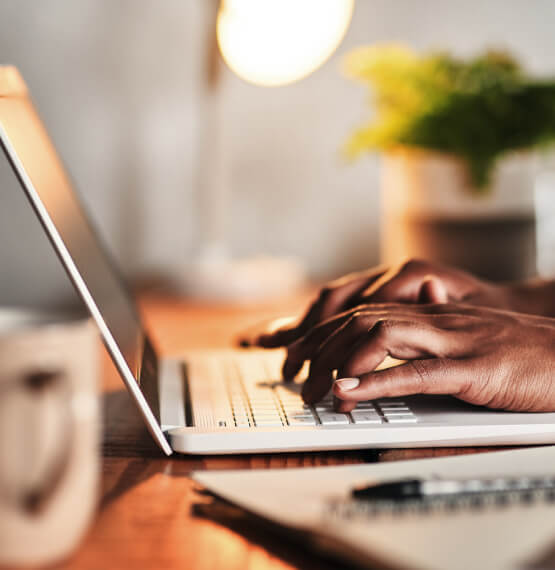 Hands typing on a laptop