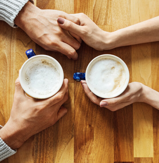 People holding hands with coffee