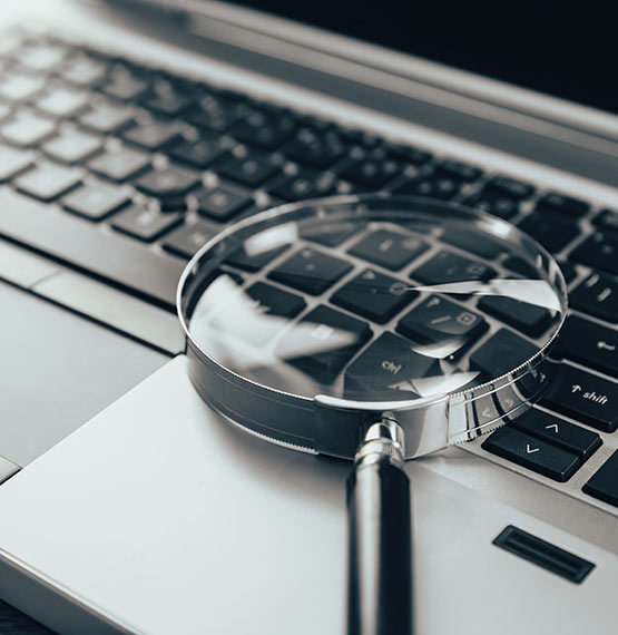 laptop with magnifying glass on keyboard