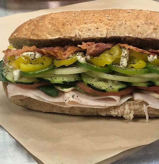 sub from Philly's Subs displayed on a paper wrapper and loaded with a variety of meat and veggies