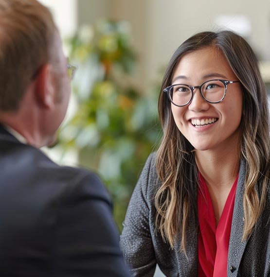 young Asian woman smiling while talking with a banker/lender