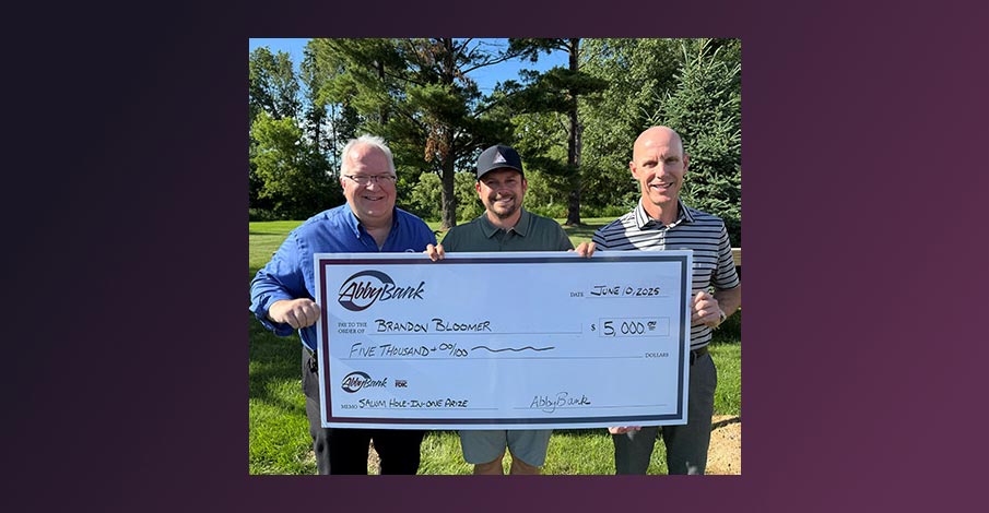 Jim with AbbyBank posing with Brandon Bloomer, winner of $5,000 hole-in-one prize, and Shawano Lake Golf Course manager holding a large AbbyBank check for the $5,000 hole-in-one prize for the Shawano Area Waterway Management golf outing
