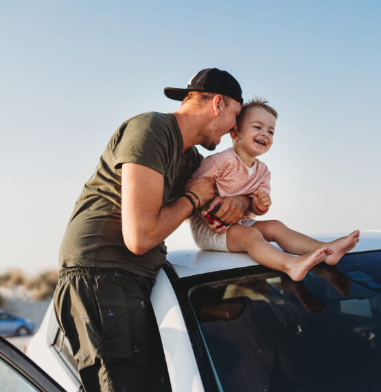 Father and son on top of car