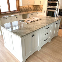 kitchen with white cabinets and golden color quartz countertops by Stone Creations in Shawano, WI