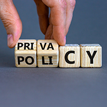 hand overturning wooden cubes with the words "Privacy Policy"