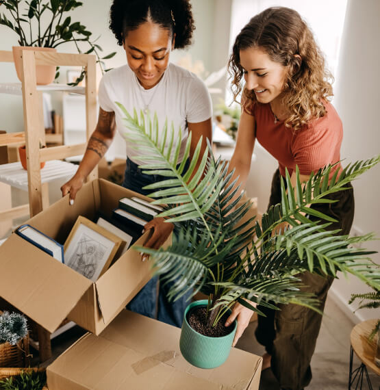 Two young woman packing boxes