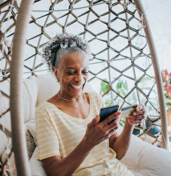 Woman holding phone and debit/credit card