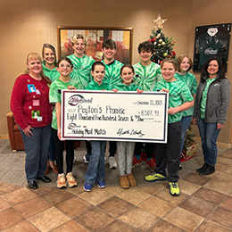 photo of Peyton's Promise advocates and AbbyBank employees holding large AbbyBank check showing the amount we helped raise during our 2023 Holiday Meal Matching Funds campaign