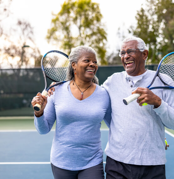 A mature couple with tennis rackets