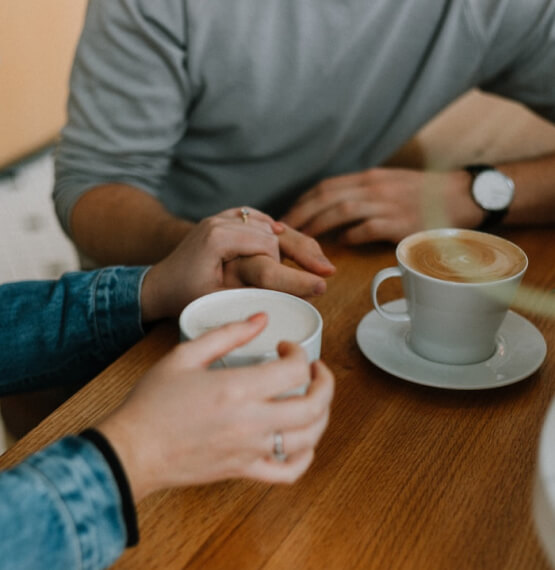 Couple holding hands while having coffee