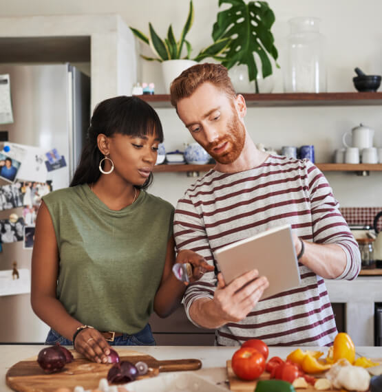 Couple in kitchen using tablet device