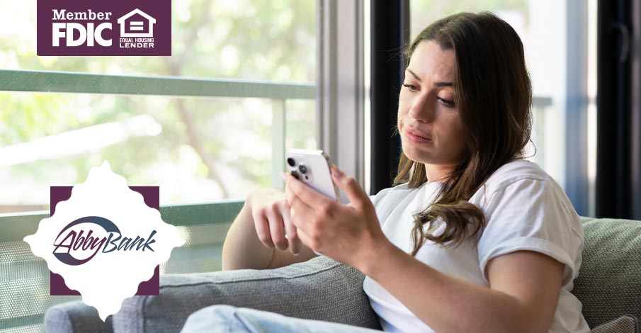 woman on couch looking concerned while checking phone