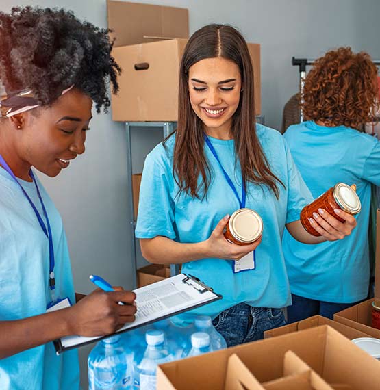 young women volunteering at food pantry sorting food donations